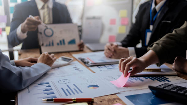 istock Teamwork process. Business people pointing at business document during discussion at meeting. 2155117138
