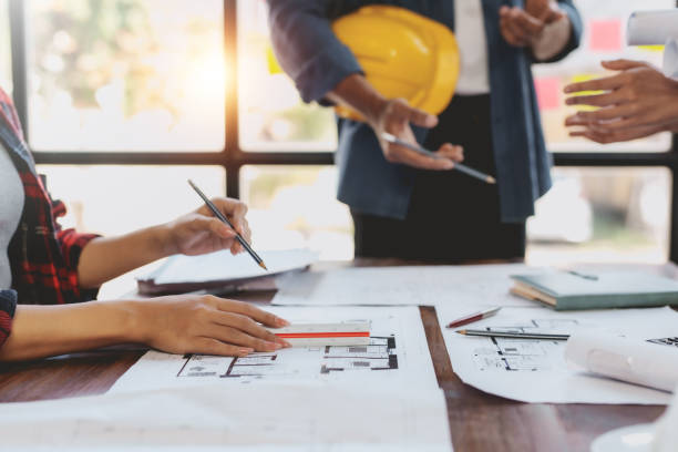 istock Architect or engineer are meeting to discuss house designs, modify plans for construction projects, and additions according to customer needs. 2155117311