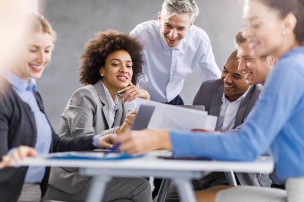 istock Happy business team analyzing reports on a meeting in the office. 2155117373