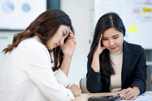 istock Two asian business woman stressed over financial documents. Corporate strategy and problem-solving concept 2155118362