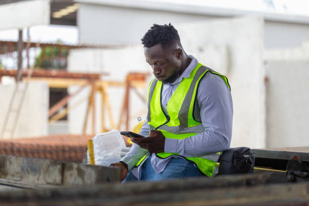 istock Engineer man takes a break in the precast factory site, Foreman worker using mobile smartphone at the construction site 2155119140