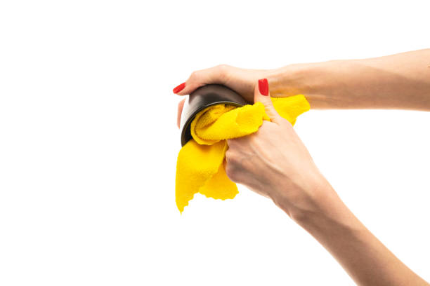 Woman wiping black cup with towel in kitchen, closeup. High quality photo