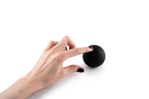 istock Massage black ball in female hand for trigger points isolated on a white background. Concept of myofascial release. 2155121868