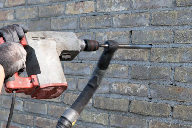 Drilling holes in a pattern in the joints between the bricks of the outer wall. After drilling these holes a mechanic will spray a mixture of various chemicals into those holes. The mixture will fill the hollow between the inner and outer wall and become an insulating foam.