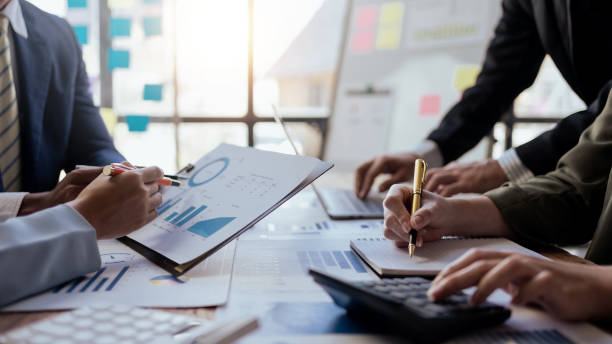 istock Teamwork process. Business people pointing at business document during discussion at meeting. Business people meeting explaining the financial graph data and marketing plan. 2155122687