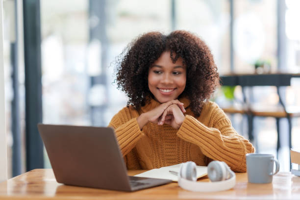 istock Cheerful young african american woman using computer laptop in coffee shop. 2155122720