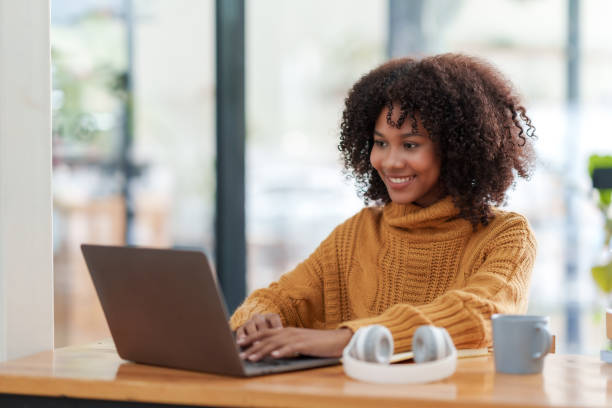 istock Cheerful young african american woman using computer laptop in coffee shop. 2155122728