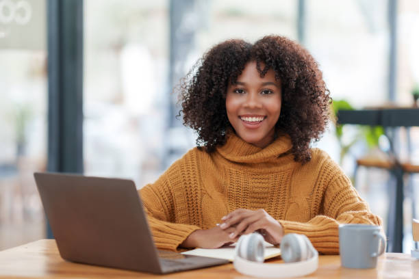 istock Radiant young woman working on laptop in a comfortable cafe environment, exuding confidence and positivity. 2155122739