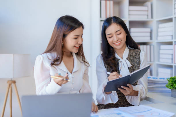 istock Two happy asian businesswoman talking and using a laptop computer in a meeting. 2155123143