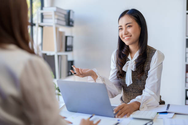 istock Two happy asian businesswoman talking and using a laptop computer in a meeting. 2155123146