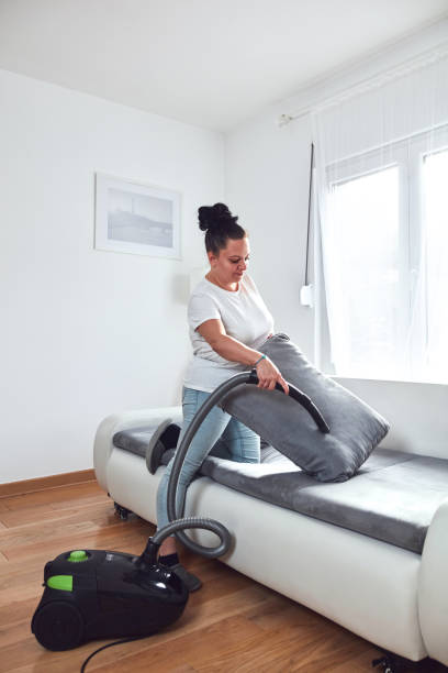 istock Woman cleaning apartment with vacuum cleaner. 2155124440