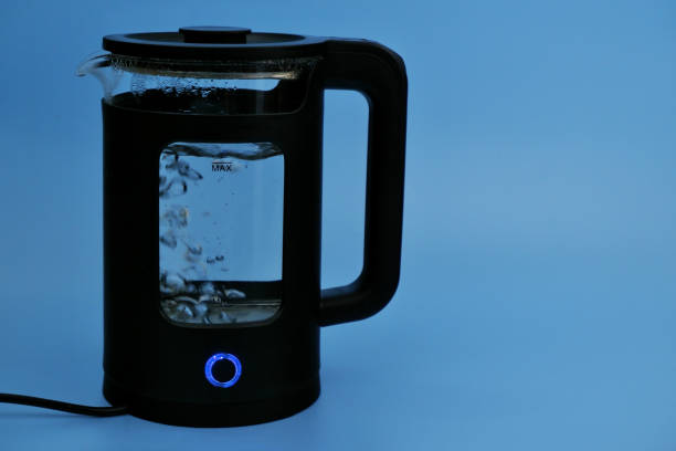 istock Water boiling in black electric kettle on blue background. 2155125138