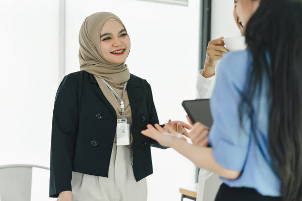 istock Colleagues engaging in friendly conversation in a modern office during a meeting break. 2155125405