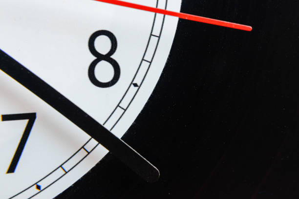 Clock vinyl record plate, arrow, backward time close-up.