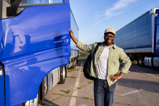 Truck driver proudly standing by his truck ready for work.