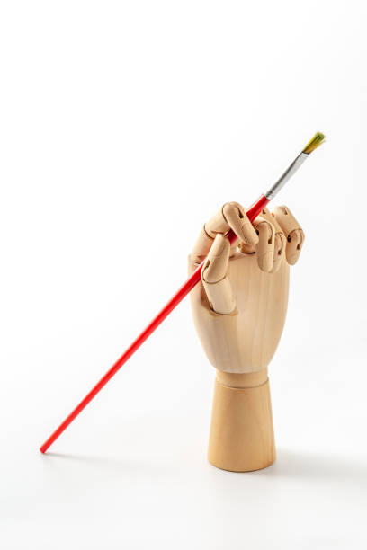 istock wooden hand with paintbrush on white background 2155128190