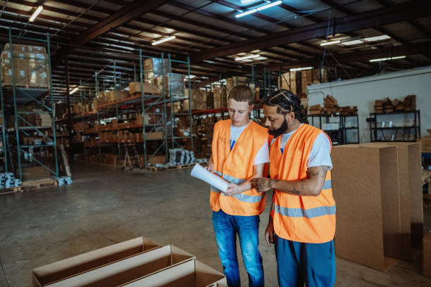 istock Factory with diverse employees having a meeting. Employees checking goods for delivery 2155128957