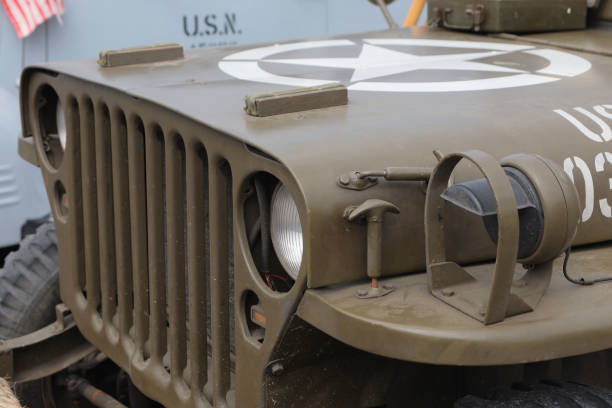 United States Army Second World War era jeep bonnet and radiator grille. This view is of the front grill and headlight arrangement of the Willys jeep, with the large white star on the bonnet to indicate to aircraft it was a friendly vehicle.
This image was taken at an outdoor event over the weekend of 25th June 2023, where reenactors, living historians, and members of the public can come to experience what life was like during the second world war, with live demonstrations, battle reenactments, and static displays from all over the world. jeep 4x4 off road vehicle world war ii stock pictures, royalty-free photos & images