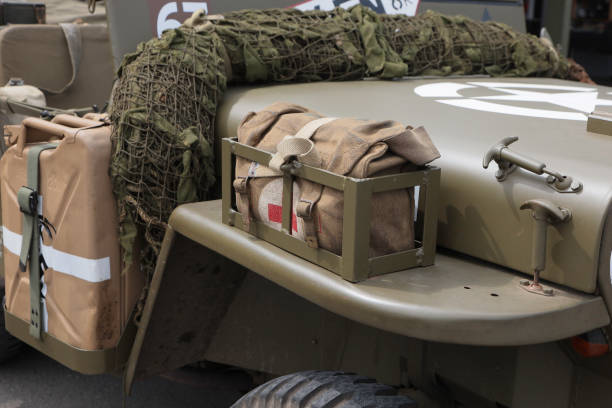 United States Army Second World War era Jeep Mounted Accessories. This view is of the front side of a Jeep, showing an easily accessible first aid kit, reserve fuel tanks and camouflage netting for concealment.
This image was taken at an outdoor event over the weekend of 25th June 2023, where reenactors, living historians, and members of the public can come to experience what life was like during the second world war, with live demonstrations, battle reenactments, and static displays from all over the world. jeep 4x4 off road vehicle world war ii stock pictures, royalty-free photos & images