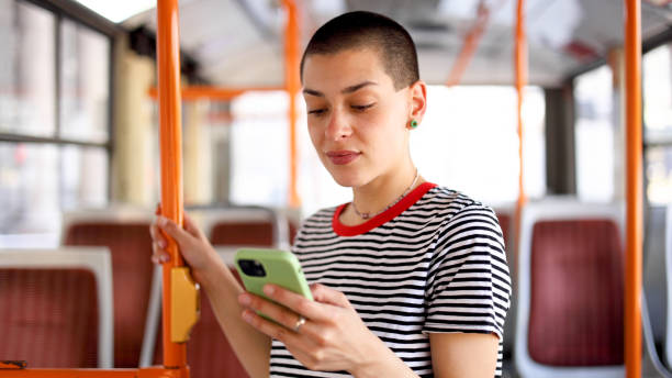 istock Young, short-haired woman in a bus surfing the net 2155131079