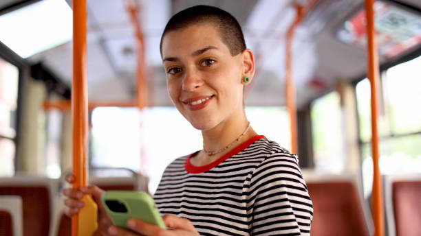 Young, short-haired woman in a bus surfing the net