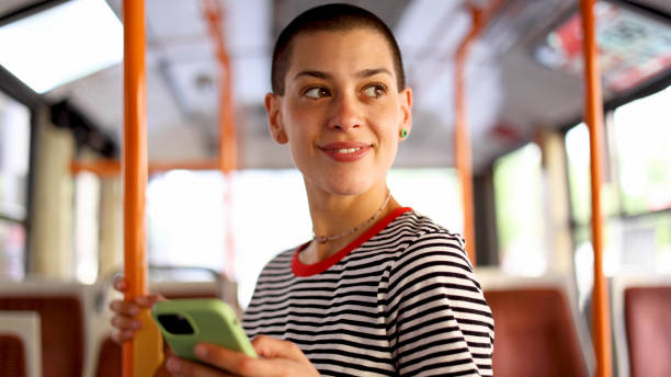 istock Young, short-haired woman in a bus surfing the net 2155131392