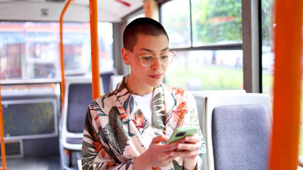 istock Beautiful short-haired girl riding in a bus and using smartphone 2155131446