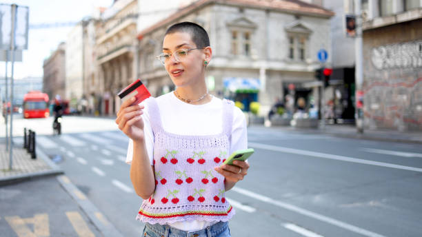 Young short-haired woman using smartphone on the street