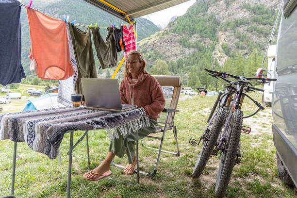 istock Woman Working on Laptop at Scenic Campsite with Drying Clothes 2155136534