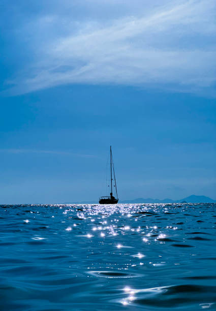 istock Sailing Boat Silhouette on Calm Blue Sea at Sunset 2155137055