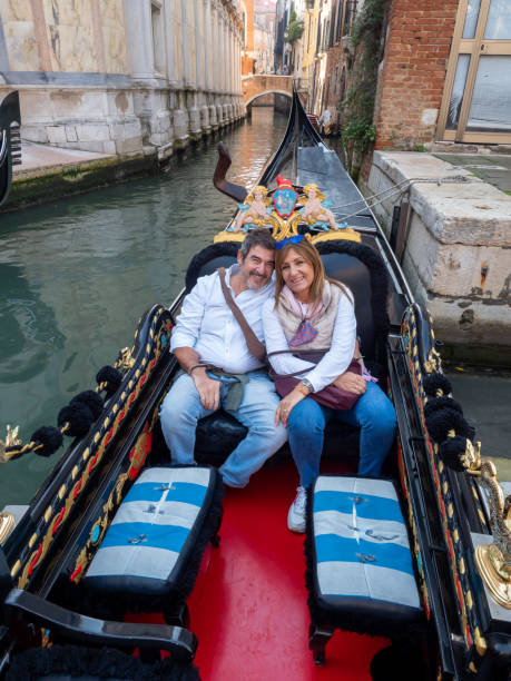 istock Couple smiling while enjoying a ride in a gondola in Venice, Italy. 2155142308