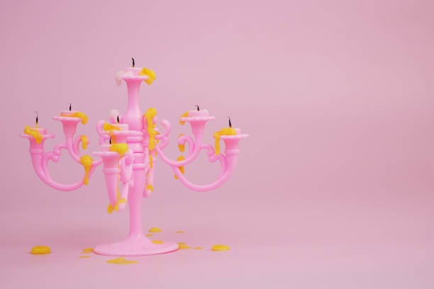 Candelabra with melted yellow candles on pink background.