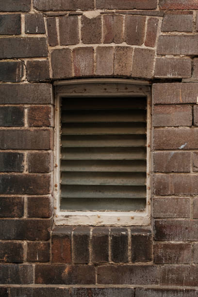 istock Old brick wall with a louvered glass window 2155147561
