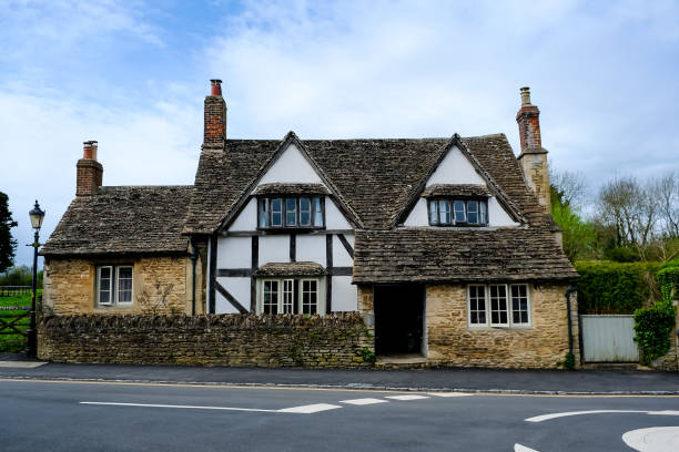 Lacock, Wiltshire, Cotswolds, England, UK - 08.04.2024. The historic and well preserved village of Lacock, in county Wiltshire is popular tourist stop. The medieval village of Lacock in Wiltshire, with its timber-framed cottages and stunning abbey, has to be one of the prettiest villages in England. It's picturesque streets, historic cottages and century inns make it a firm favourite with film and TV producers. The village’s most famous appearances include Downton Abbey, the BBC’s Pride and Prejudice and Cranford, and the Harry Potter films.