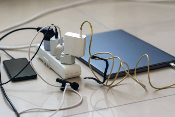 istock Electrical outlet with many chargers connected to it for a smartphone, laptop, microphone 2155148190