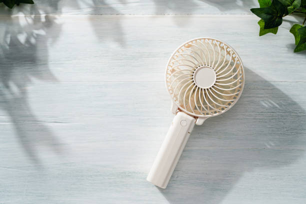 istock Portable electric fan on wooden table 2155148693