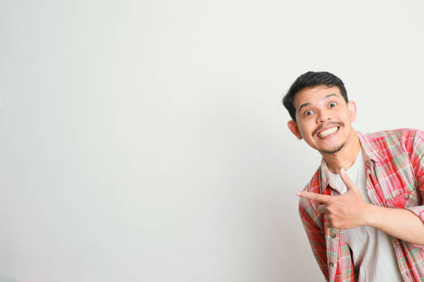 istock an asian man smiles and points to something with his hand 2155148973