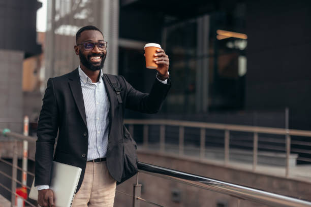 istock African businessman outdoors holding laptop and take away coffee cup 2155149752