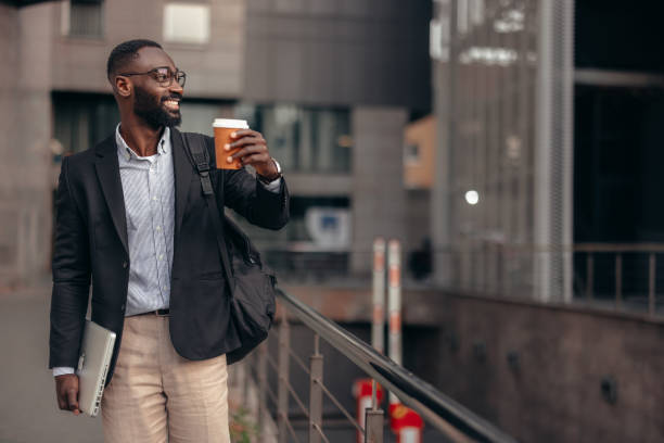 istock African businessman outdoors holding laptop and take away coffee cup 2155149759
