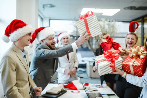 istock Smiling Office Workers Celebrating Christmas By Giving Each Other Presents 2155150926