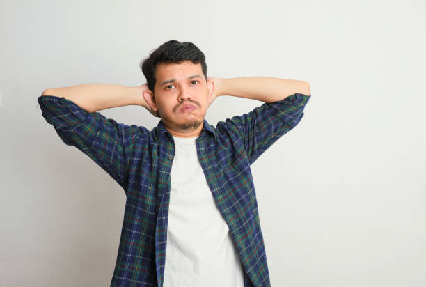 istock a young asian man holds his head with a sad and disappointed expression 2155150977