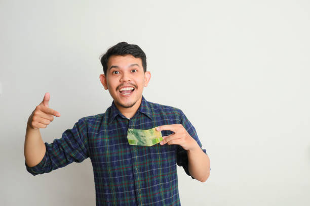 istock Man cheerful smile with a money in hand 2155150978