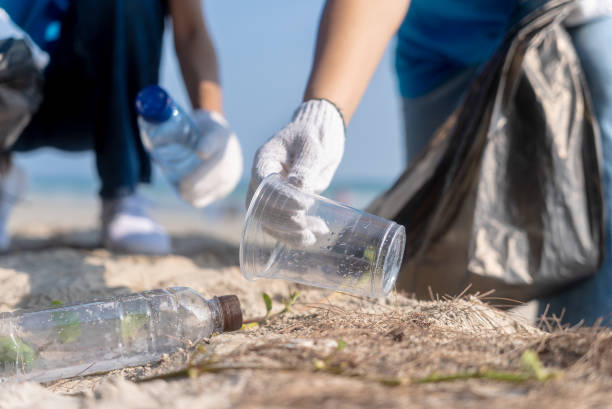 istock Plastic pollution and environmental problem concept. Close up of female volunteers hands with collecting plastic cup on the beach. Greening the planet. Recycle reduce and reuse concept. 2155151159