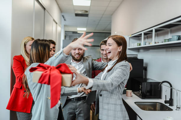 istock Excited Female Secretary Embracing Colleagues While Receiving Birthday Gift 2155151663