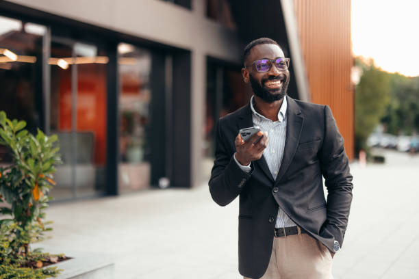istock Smiling business man using smartphone outside the office 2155154262