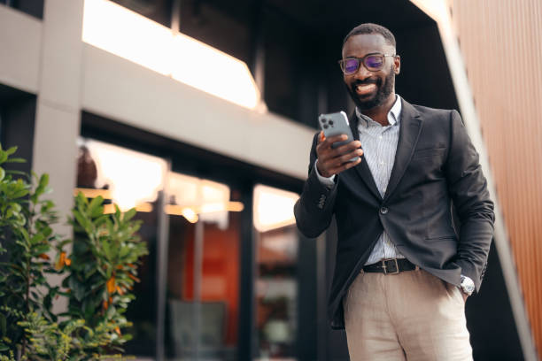 istock Smiling business man using smartphone outside the office 2155154276
