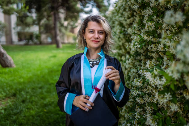 istock Happy graduate student holding his diploma on graduation day 2155154804