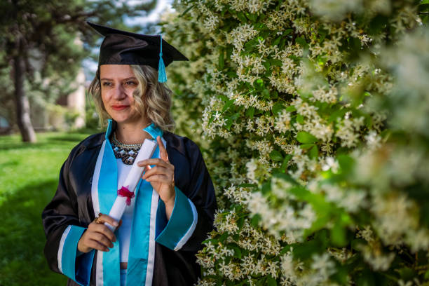 istock Happy graduate student holding his diploma on graduation day 2155154871
