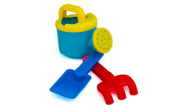 Curious Asian boy plays joyfully in the indoor playground sandbox, building an imaginative sandcastle with colorful plastic tools, developing sensory awareness, fine motor skills, and creative thinking through fun learning playtime