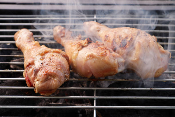 istock Chicken legs cooking on charcoal oven close up. 2155159367